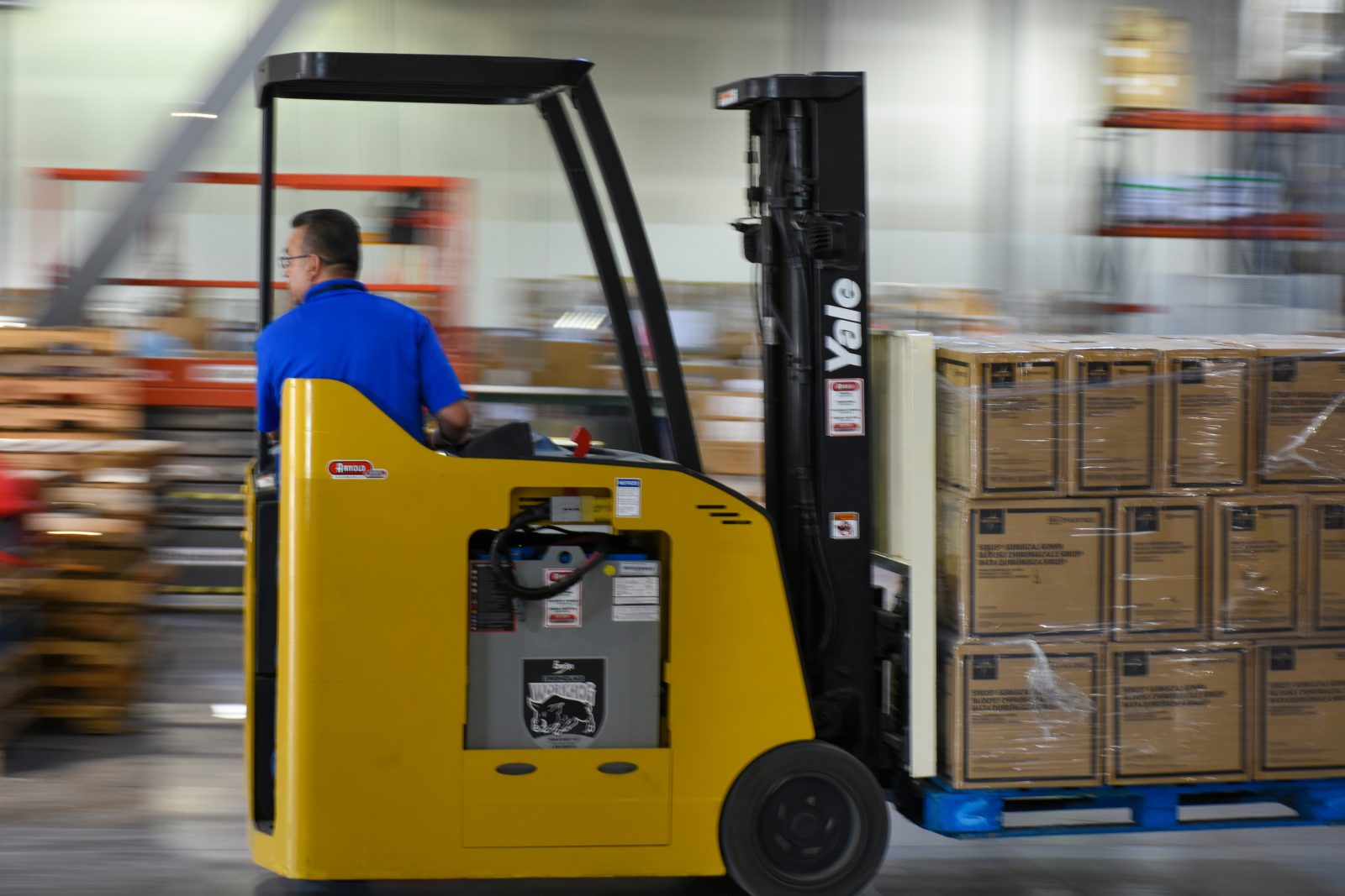 A forklift driver moves supplies for Project C.U.R.E.