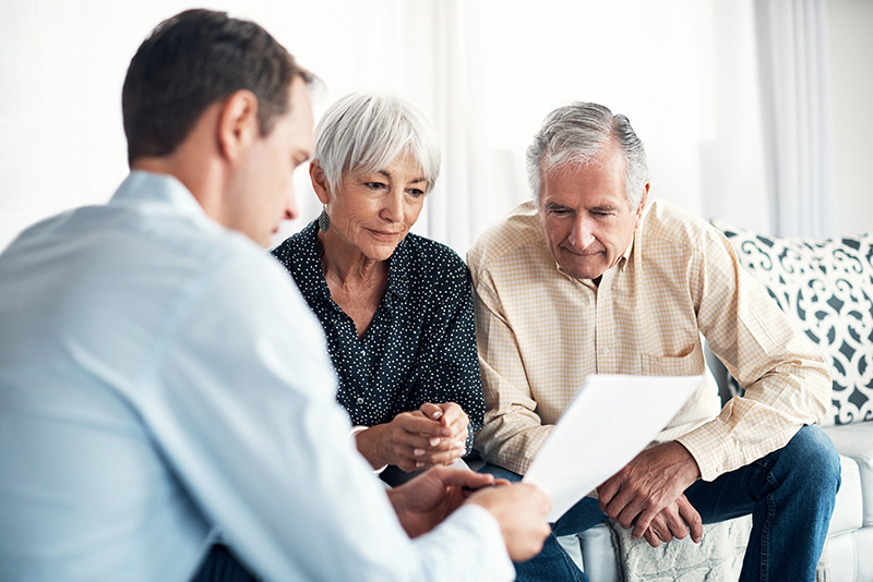 an elderly couple looking at paperwork