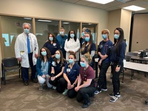 Care givers at UCHealth Memorial Hospital Central are photographed with Dana Ikener, a patient who recovered from COVID-19