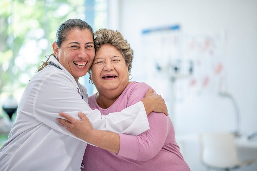 A doctor hugs her patient. finding a primary care doctor you trust is important.