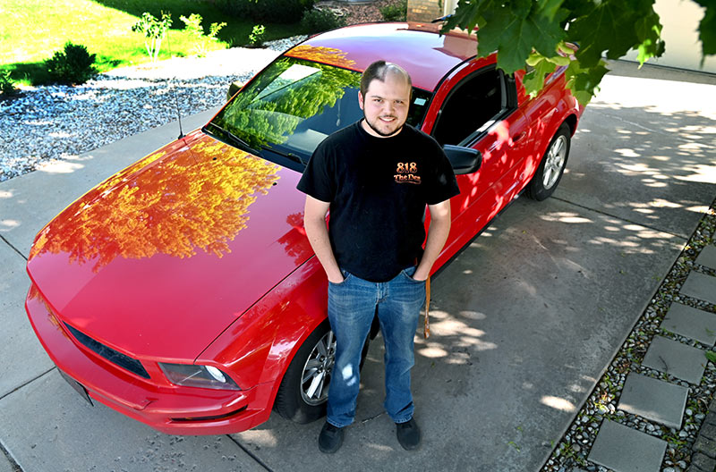 Jack O'Donnell, who is living with oligodendroglioma, in front of his car.
