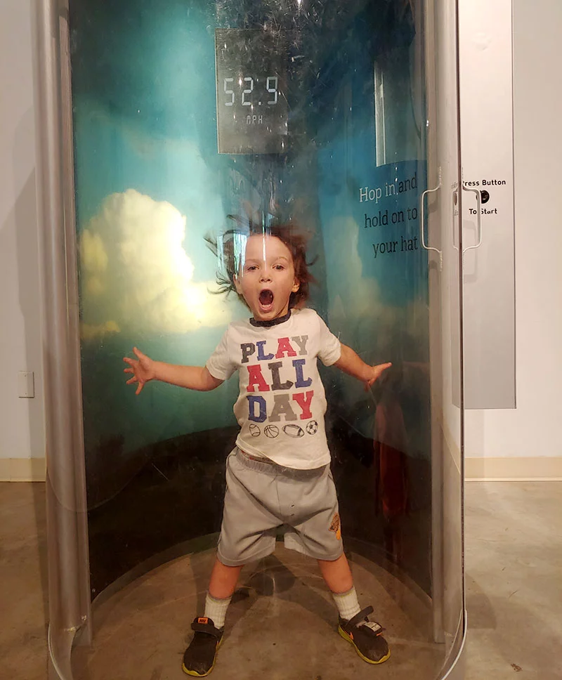 A visitor to the Fort Collins Museum of Discovery experiences hurricane winds. Photo by Kati Blocker, UCHealth.