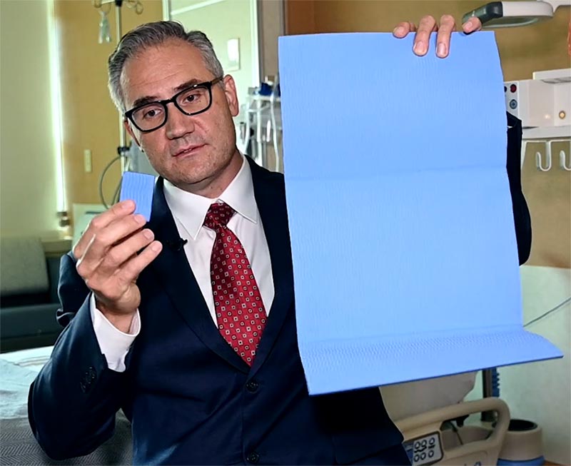 Dr. Arek Wiktor comparing the size of harvested skin a single ReCell kit can process with the spray coverage that kit can produce. Each kit can convert four 3-by-2 centimeter skin biopsies to cover an area that might otherwise require donor grafts as large as a patient’s entire back. Photo by Sonya Doctorian for UCHealth.