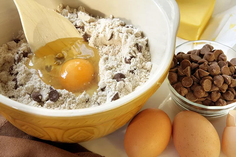 Cookie dough may be tasty, but eating raw eggs can lead to foodborne illness. To stay safe, always cook eggs to 160°F and watch for symptoms like nausea or cramps. Photo: Getty Images.