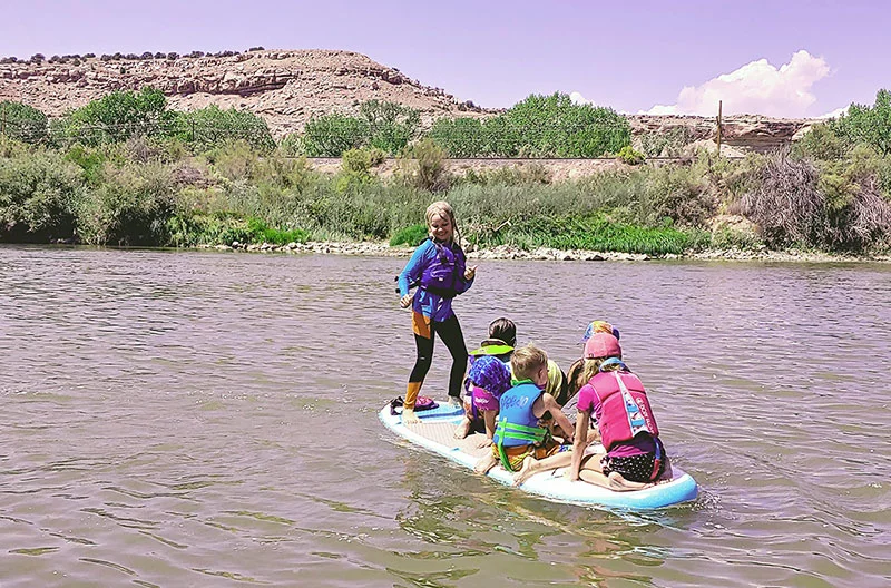With life jackets on and adults nearby, kids safely enjoy the Colorado River. Photo by Kati Blocker, UCHealth.