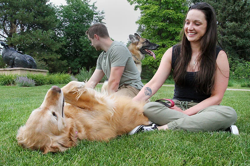 Erica Brown with her husband, Matt Brown, and dogs, Ella and Sinatra, in a park in Loveland, Colorado. Photo by Joel Blocker, for UCHealth.