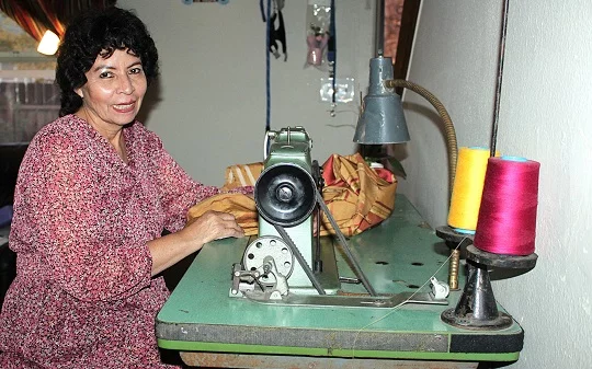 Haidee muestra la máquina de coser antigua que durante muchos años, antes de desarrollar cáncer de mama, le sirvió de herramienta de trabajo para obtener ingresos extras y así poder sostener a su familia. Foto: Ana Gretchen Robleto L., para UCHealth. 