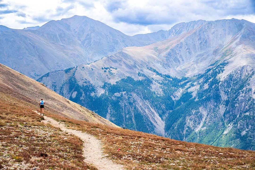 Dr. Anne Flower, an ER doctor at UCHealth Memorial Hospital Central in Colorado Springs, runs the Leadville Trail 100 race. View of Flower from behind with mountains in the background. The Leadville 100 is known as the "Race Across the Sky." Photo by Peter Maksimow.