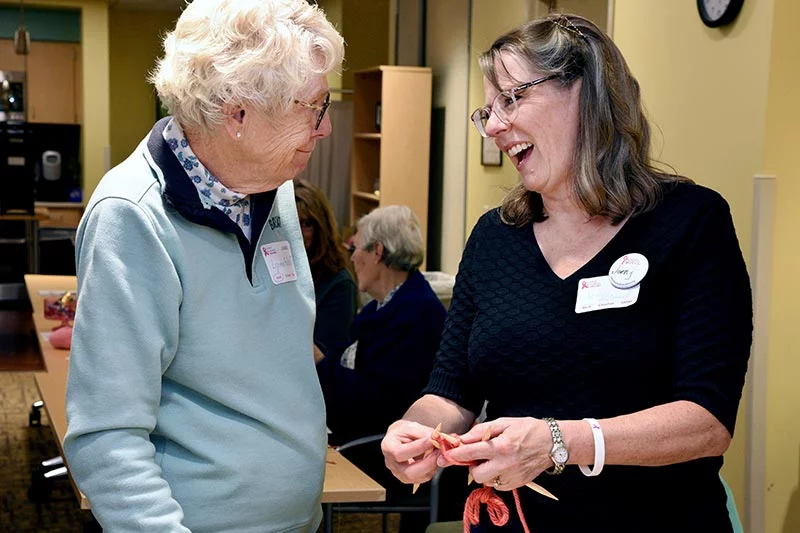 Knitting coach Jenny McConnell, right, demonstrates a knitting style to Knit-a-thon participant Lynne Felicelli. As a member of Colorado Knitted Knockers, Jenny has knitted several hundred knockers over the past five years, she said. Photo by Sonya Doctorian, UCHealth.