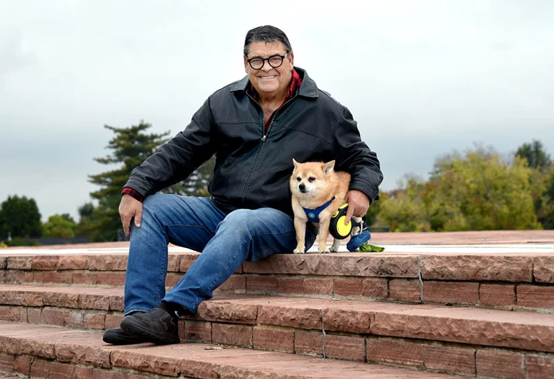 Jensen in Cranmer Park with Jordy, a dog he cares as part of his dog-walking and housesitting duties for a Denver client. Photo by Sonya Doctorian, UCHealth.