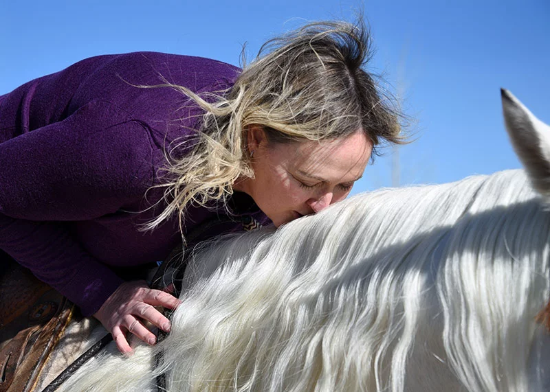 Carey kisses Johnny Ringo MMR's mane after their first ride together in several months.Photo by Sonya Doctorian, UCHealth.
