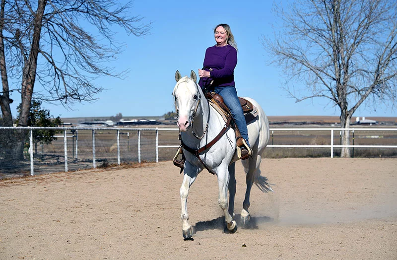 After a few minutes of walking and trotting, Carey smiles through tears as she urges Johnny Ringo MMR into a lope around the Rock'n W Ranch arena in Weld County, Colorado. Photo by Sonya Doctorian, UCHealth.