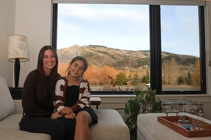 Large windows in Sydney and Genevieve's apartment look out over Mount Werner, Steamboat's ski mountain. Sydney grew up in Steamboat Springs before it became increasingly difficult to afford to live there. Thanks to affordable housing at Creek's End, this single mother can afford to live and work in her hometown. Photo by John Russell, for UCHealth.