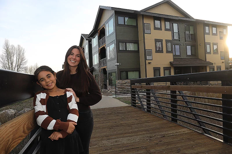Sydney Lanham and her daughter, Genevieve, post outside of their affordable home in Steamboat Springs, Colorado. Sydney is a nurse at Yampa Valley Medical Center and can afford to live in her hometown thanks to a $30 miilion investment in employee housing. Photo by John Russell, for UCHealth.