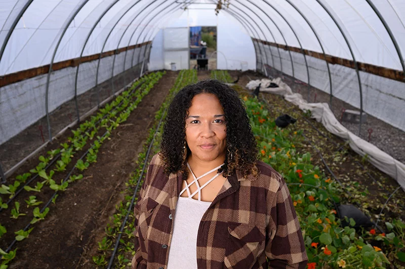 Patience Kabwasa, executive director of Food to Power, stands in one of the greenhouses at the organization's headquarters in the Hillside neighborhood in southeast Colorado Springs. She started volunteering with the nonprofit in 2015 and joined a year later as a staff member. Photo by Mark Reis, for UCHealth.