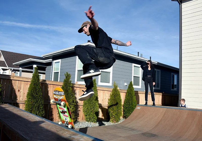 Colin Kiesel executes a kick flip on his backyard mini half pipe as Natasha and Will look on. The combination of a rare NRG1 fusion in his stage 4 pancreatic cancer and a promising new drug targeting that fusion have kept him on his board. Photo by Sonya Doctorian, UCHealth.