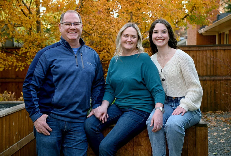 Carey Benson with her support team, husband Paul Soucek, "bonus daughter," Sofia Soucek, 16, and Duncan, Australian Shepherd, in their Denver backyard. Photo by Sonya Doctorian, UCHealth.