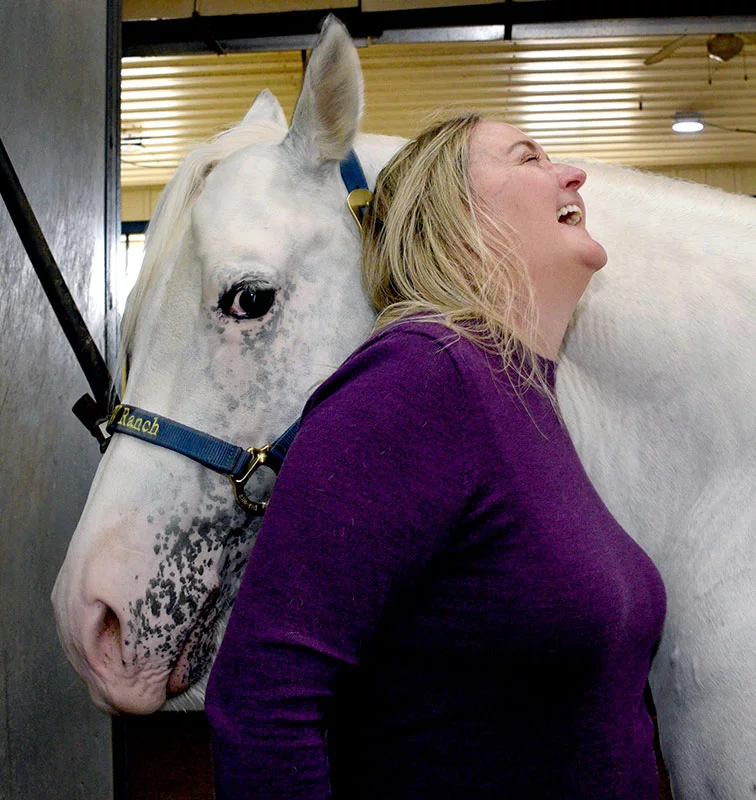 After Carey unsaddles Johnny Ringo MMR, she laughs as he nuzzles her shoulder. "Getting back on a horse is a milestone," she said, "another step to recovery." Photo by Sonya Doctorian, UCHealth.