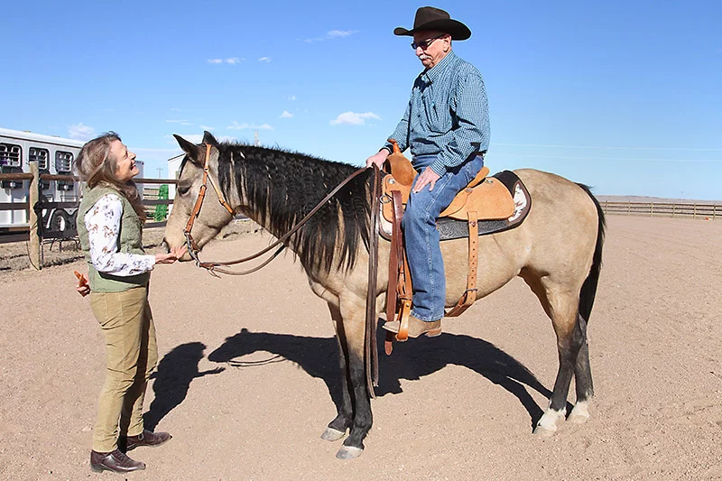 Annika Kostrubala, left, greets Bob Percival and his horse Marley on a sunny Sunday morning at Bob’s ranch near Carr, Colorado. Annika, a physician assistant at UCHealth Pulmonology Clinic – Harmony Campus, helped Bob manage his severe COPD so he could return to riding. An equestrian herself, Annika understood his passion and recently visited the ranch to see how far Bob has come. Photo by Joel Blocker for UCHealth.