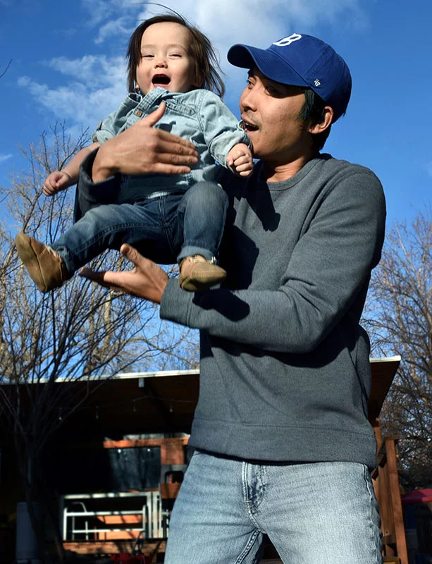 Grayson laughs and laughs as Nhanh gently tosses him in the air. In 2021, Nhanh sold his Denver restaurant, Pho-natic, to his mother because of the ongoing pandemic and Brooklyn’s birth that September. His role as a stay-at-home parent expanded when twins Grayson and Summer were born prematurely 15 months ago. Photo by Sonya Doctorian, UCHealth.