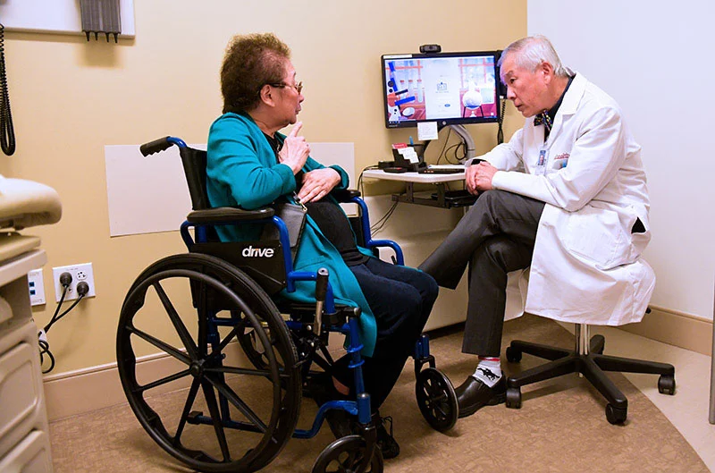 Chiang Jones gets Dr. CT Lin's advice about different types of wheelchairs that might improve her mobility. Thanks to his AI scribe, Lin can focus 100% on his patients and doesn't have to spend hours every week updating patients' medical records. Photo by Cyrus McCrimmon, for UCHealth.