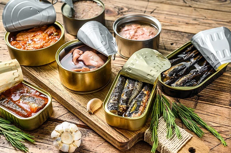 A selection of tinned fish and seafood is shown, offering easy options for quick meals and simple recipe ideas. Photo: Getty Images.