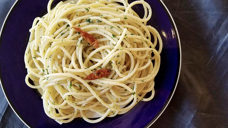 A plate of aglio e olio using long-form pasta. Here, bucatini. Photo by Bill St. John, for UCHealth.