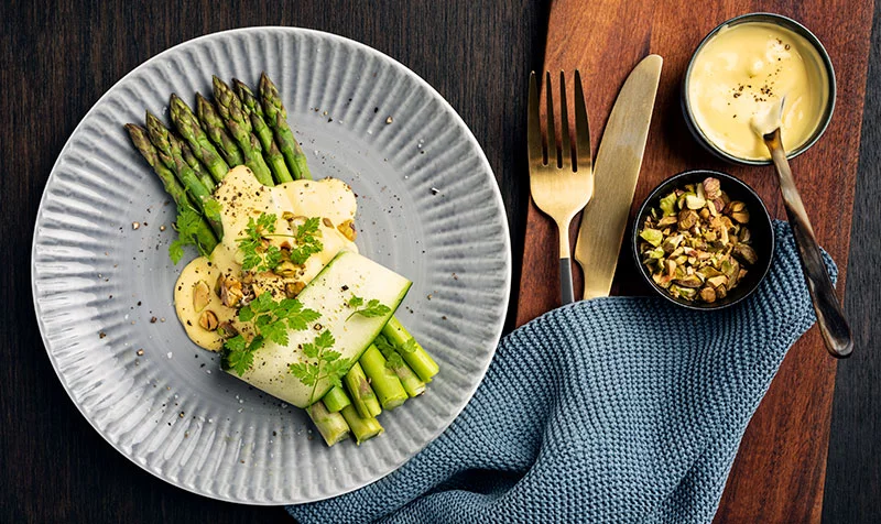 Hollandaise is one of the classic French “mother sauces,” a warm emulsion of egg yolks, butter and lemon juice. When made from scratch, it comes together quickly and delivers a rich, silky finish to seasonal vegetables like asparagus, like in this image. Photo: Getty Images.