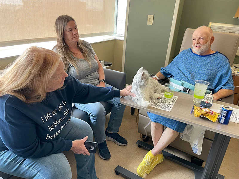  Richard Walker with sisters Donna Delano, who strokes the companion pet, and Janet Clute. Photo by Todd Neff, for UCHealth.