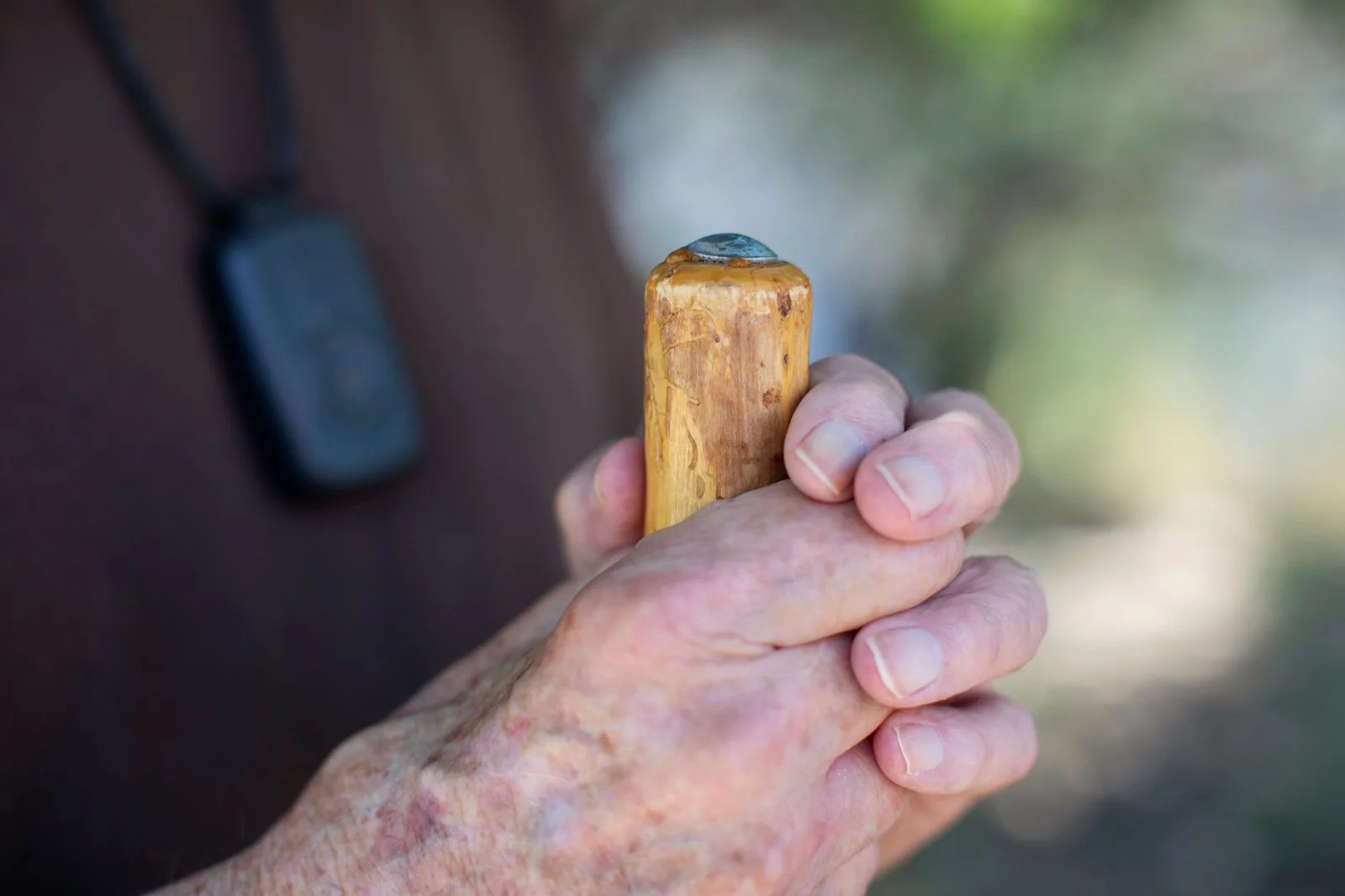 Ray White's 89-year-old hands holding his special walking stick. One of Ray White's friends made the walking stick he has used for more than 300 miles. Photo by Anslee Wolfe, for UCHealth.