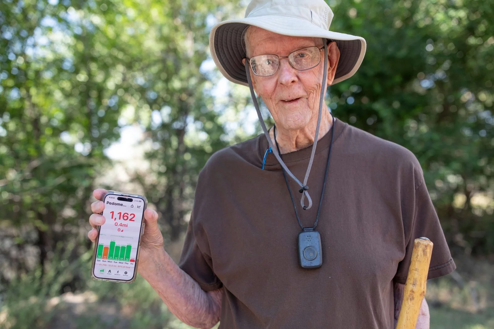 Ray White holding his photos out that shows his steps. Ray White uses his phone to track his steps each day, then converts the steps into miles. While he walks, he also uses his phone to listen to audiobooks through a Bluetooth connection to his hearing aids. Photo by Anslee Wolfe, for UCHealth.Photo by Anslee Wolfe, for UCHealth.
