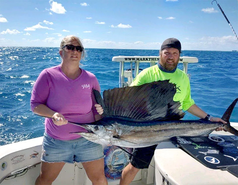 Matt and Heather caught a nearly 100-pound sailfish in the Florida Keys, which they are holding here on the fishing boat. Photo courtesy of Matt Hogue