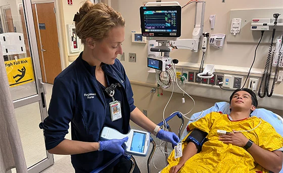 Nursing using a blood test device. ER doctors and nurses in Colorado Springs are using a new blood test to detect possible brain injuries. Many patients can avoid CT scans, saving them time and money. Photo by Joanna Bean, UCHealth.