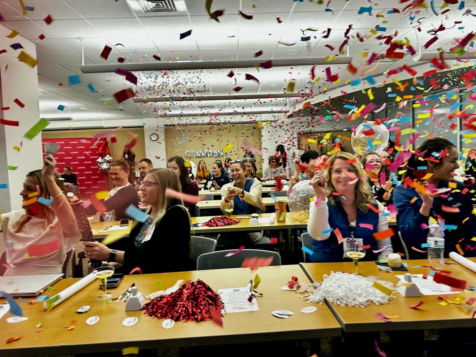 Nurses celebrate the Magnet announcement in a conference room with confetti everywhere. 