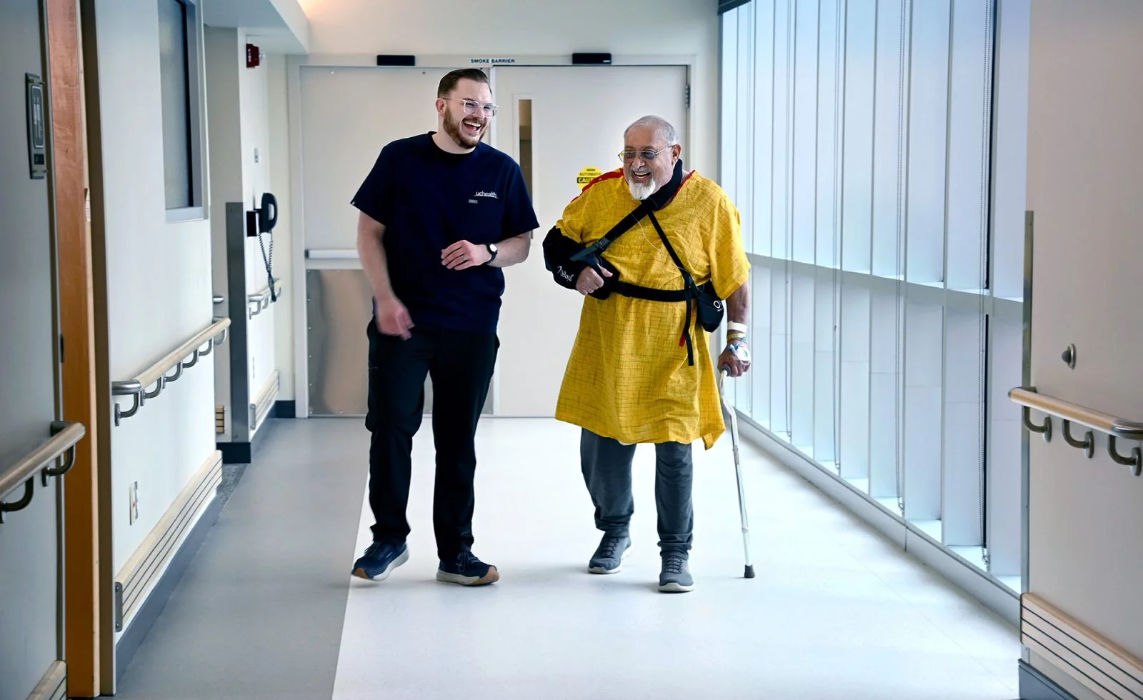 Keenan Carver and a patient walk down a hallway
