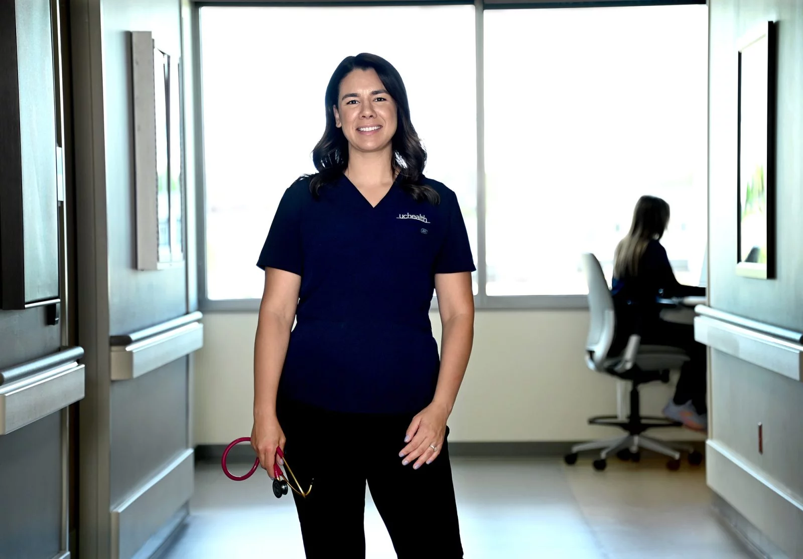 Katrina Rodriguez stands in a hospital hallway for a portrait