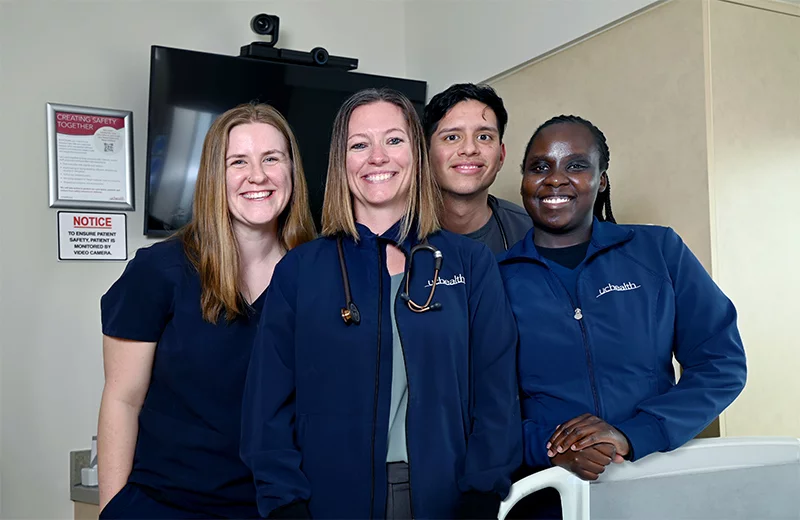 Nurses stand in a patient room, in front of a TV monitor equipped with hellocare technology. From left, Emily Lewis, acute care nurse; Leslie Tronnes, medical-surgical unit clinical nurse manager; Ander Gallo Bravo, acute care nurse; and Carolyne Chumba, acute care nurse are pictured in front of hellocare equipment. Photo by Sonya Doctorian, UCHealth.
