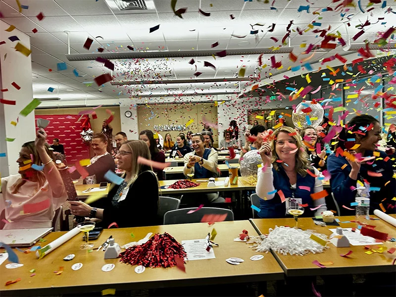Nurses celebrate the Magnet announcement in a conference room with confetti everywhere.Photo by Kelly Tracer, UCHealth. 