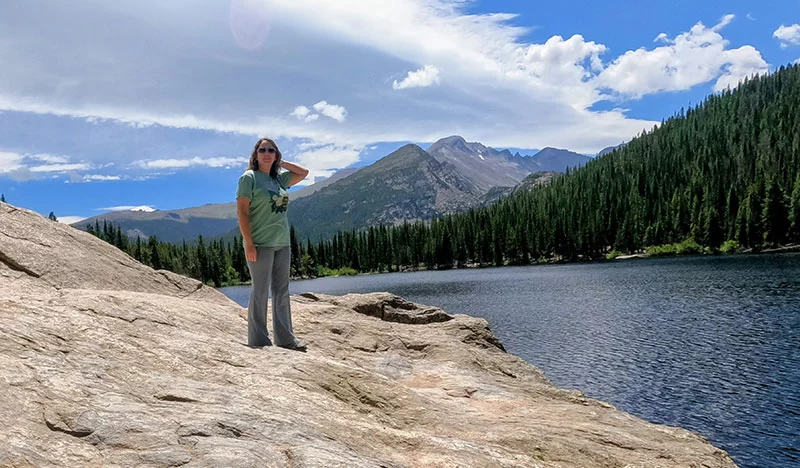 Erica Cebzanov poses with Longs Peak in the background. Erica was having a wonderful trip to Colorado and was enjoying hiking in Rocky Mountain National Park when she started to feel sick. She has long coped with medical challenges and knew she need help from medical experts. She initially received care in Estes Park. Paramedics then rushed her to Loveland, Colorado, where doctors performed emergency surgery to stop flesh-eating bacteria that could have killed her. Photo courtesy of Erica Cebzanov.