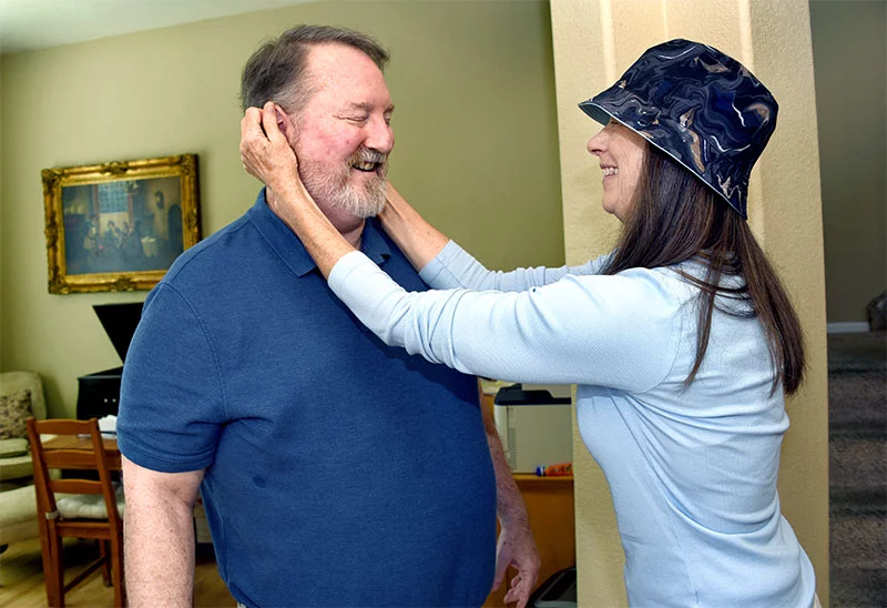 Kate D'Arcy slathers sunblock on her husband before their morning walk. He was staying up late to watch a press conference after a Denver Nuggets game when heart problems that led to a heart transplant began. Photo by Sonya Doctorian, UCHealth.