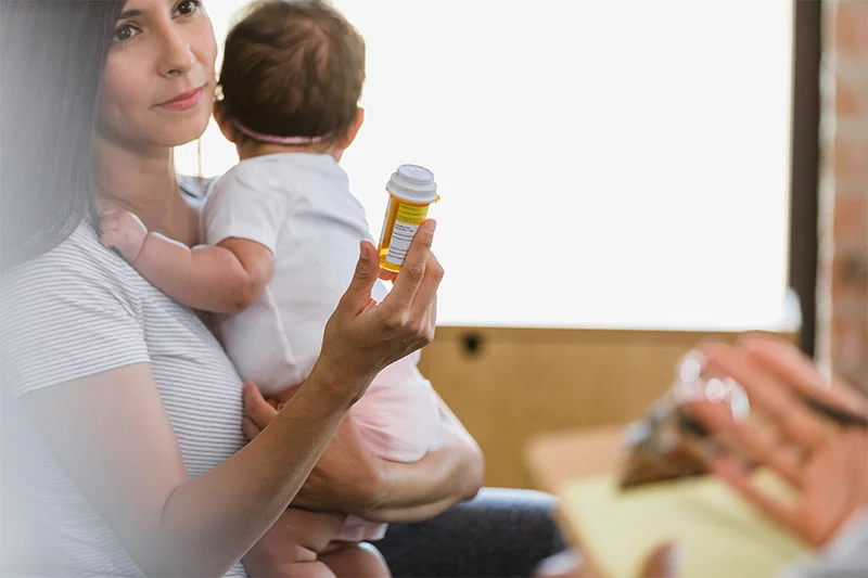 mother holding a baby and prescription while talking with a doctor. Postpartum depression affects about one in five mothers, while postpartum psychosis is less prevalent, affecting one to two women per 1,000 births. Both conditions require medical attention. Photo: Getty Images.