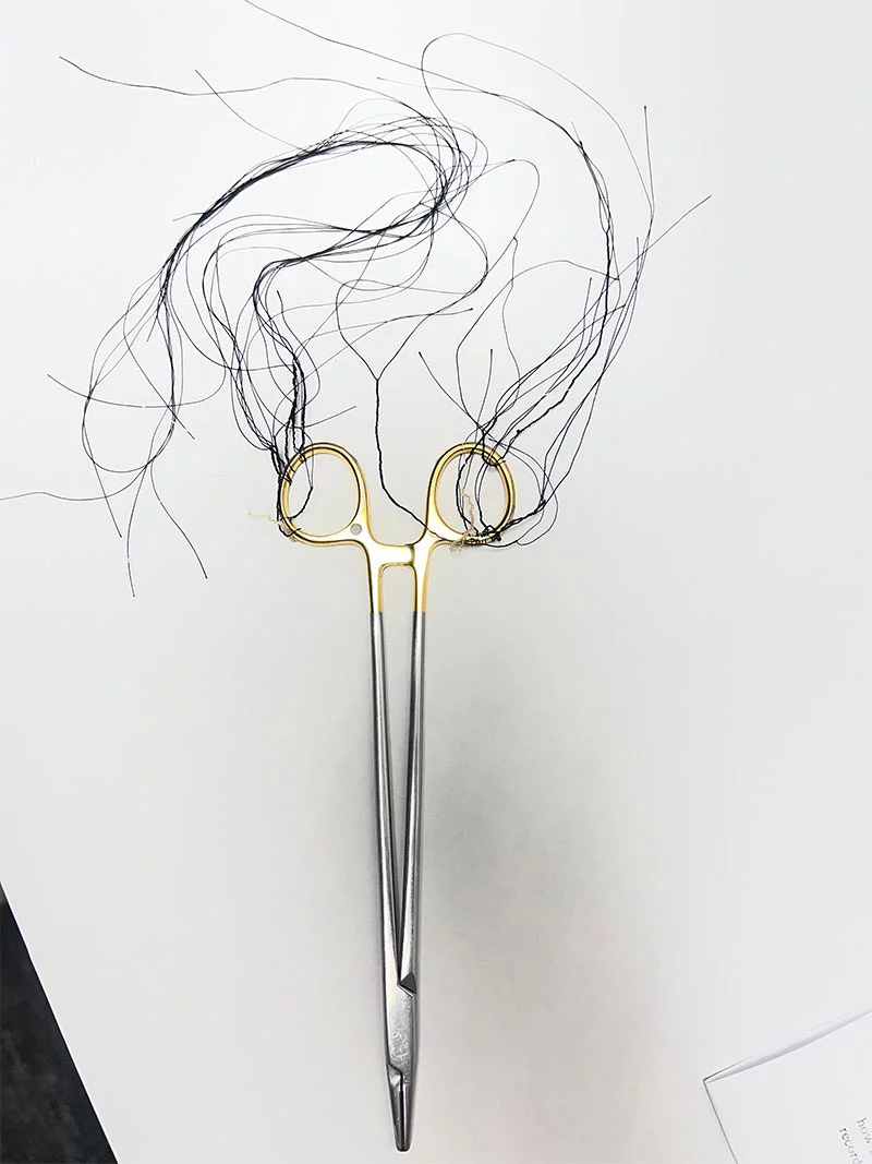 For her art show piece, Victoria Gonzales tied surgical knots in suture thread on a pair of scissors typically used in the operating room. Creating the piece helped her practice the knots and relieve stress. Photo by Joanna Bean, UCHealth.