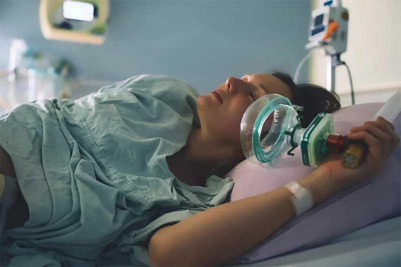 birthing mother holding nitrous oxide mask in a hospital bed. Once mostly associated with the dentist’s chair, nitrous oxide, or laughing gas, is now used in settings ranging from birthing centers and emergency rooms to med spas. But how well does it work, is it safe and what should people know about its potential risks? Photo: Getty Images.